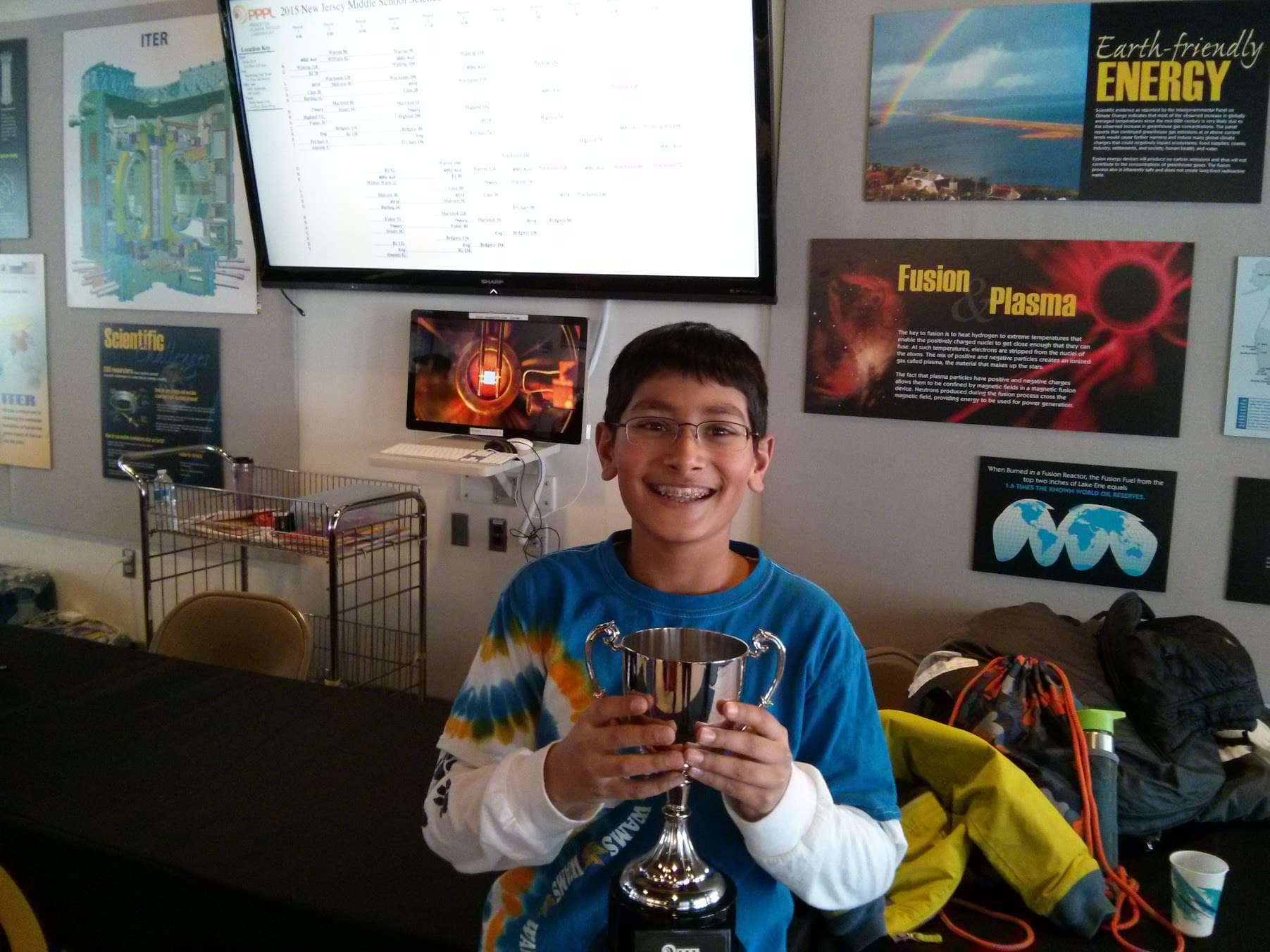 Young Rishi holding a trophy at the Princeton Plasma Physics Lab